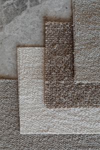 Kaboompics - Geometric Bouclé Upholstery Fabric Swatch Arrangement on Gray Stone