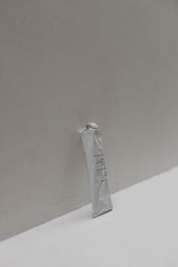 Kaboompics - UGC-Style Image of a Hand and Body Scrub Tube on a Neutral Background - Free Stock Photo