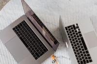 Kaboompics - Angled Pair of Open Silver Laptops on White Textured Surface