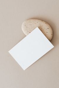Kaboompics - Blank Paper Card with Large Natural Stone on Beige Background