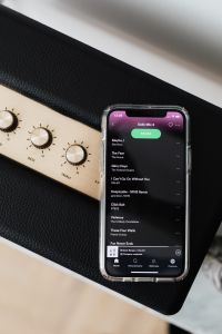 Kaboompics - Black speaker on marble table, white wall, mobile phone