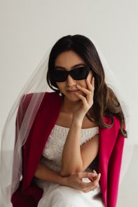 Kaboompics - Fashion-Forward Bride in a Fuchsia Blazer Resting Her Chin on Her Hand