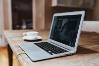 Kaboompics - Laptop with a coffee cup on a wooden table