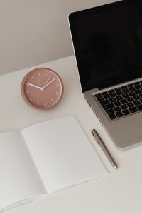 Kaboompics - Pink Clock and Open Notebook in Minimal Home Office