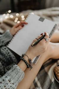 Kaboompics - Writing in a notebook lying in bed, with coffee, candles, and gingerbreads
