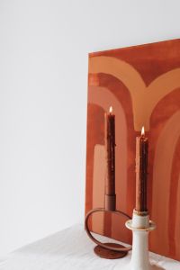 Kaboompics - Taper Candles and Terracotta Wall Art with Generous White Negative Space
