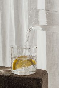 Kaboompics - Transparent Pitcher Pouring Water Over a Lemon Slice