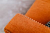 Kaboompics - Close-Up of Burnt Orange Sofa Cushion with Visible Upholstery Stitching