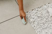 Kaboompics - Woman Wiping a Floor Edge Beside Decorative Stones