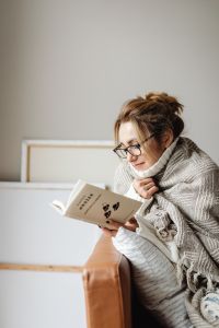 Kaboompics - Woman Reading Under a Blanket in a Cozy Stay-at-Home Moment