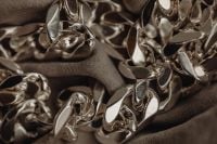 Kaboompics - Close-Up of Sculptural Silver Chain Links on Dark Fabric