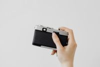 Kaboompics - Rear View of a Vintage Camera Held in One Hand Against White