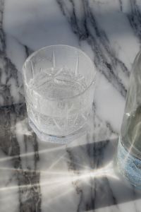 Kaboompics - Empty Water Glass on White Marble with Reflections