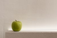 Kaboompics - Single Green Apple on a Textured Stone Ledge, Vertical Minimalist Food Background