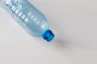 Kaboompics - Diagonal Clear Bottle with Blue Neck on White
