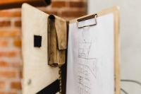 Kaboompics - Open Tan Leather Portfolio with a Clipped Building Sketch Against a Brick Wall