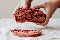 Kaboompics - Hands Holding Beetroot Bread with Sliced Loaf Below