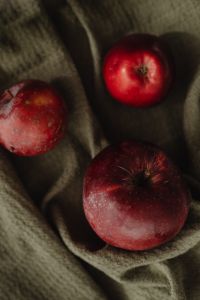 Kaboompics - Macro Close-Up of Red Apples on Dark Linen, Rustic Autumn Fruit Texture