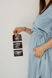 Kaboompics - Pregnant Woman Holding Ultrasound Scans in Blue Dress