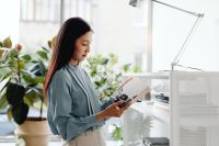 Kaboompics - Asian Woman Reading an Open Notebook by a Bright Window