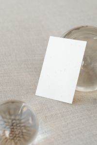 Kaboompics - Portrait Business Card Mockup Beside a Glass Orb on Beige Linen