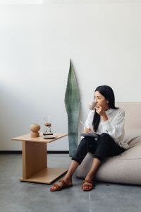 Kaboompics - Woman Drinking Coffee Beside a Small Wooden Table