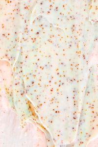 Kaboompics - Vertical Pale Mint and Peach Exfoliating Cream Texture with Orange Granules