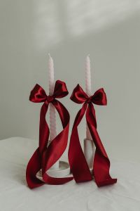 Kaboompics - Pair of White Candles Tied with Oversized Red Bows