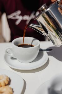 Kaboompics - Pouring coffee into a cup. Silver kettles, Italian cookies.