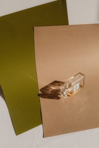 Kaboompics - Glass Perfume Bottle on Green and Brown Paper