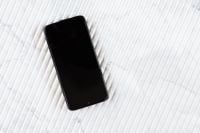 Kaboompics - Angled Black Phone on White Ribbed Marble, Minimalist Mobile Technology Background
