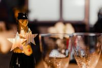 Kaboompics - Champagne Bottle with Star Ornament and Gold-Dotted Glasses for New Year