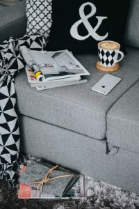 Kaboompics - Coffee Cup, Open Magazine and Smartphone on Textured Gray Sofa