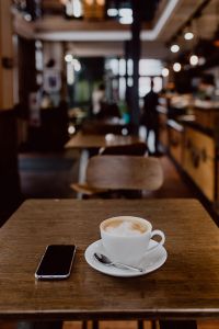 Kaboompics - Cup of coffee on table in cafe, iPhone mobile phone