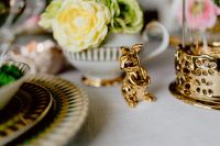 Kaboompics - Pair of Gold Rabbit Figurines beside a Floral Teacup on a Patterned Gold Plate