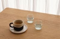 Kaboompics - Black and Tan Coffee Mug with Spoon, Saucer and Water Glasses