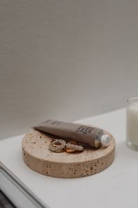 Kaboompics - UGC-Style Image of a Hand and Body Scrub Tube on a Neutral Background - Free Stock Photo