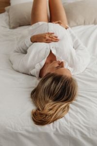 Kaboompics - Pregnant Woman Lying on a Bed in a White Robe