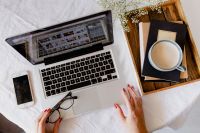Kaboompics - Overhead Laptop and Coffee Workspace with Smartphone, Eyeglasses, Books and Baby’s Breath Flowers