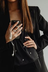 Kaboompics - Black Suit Businesswoman with Smartphone and Wired Earphones