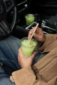 Kaboompics - Woman Stirring Iced Matcha in a Car