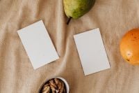 Kaboompics - Pear and Orange with Two Blank Branding Cards and Walnuts on Beige Linen