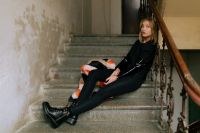 Kaboompics - Black Streetwear Portrait Seated with Legs Extended on Weathered Factory Stairs