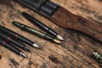 Kaboompics - Assorted Fountain Pens With Exposed Nibs on Rustic Wood