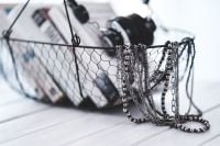 Kaboompics - Layered Necklaces Draped over a Wire Basket of Books