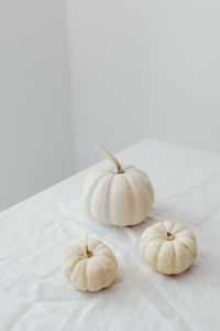 Kaboompics - Three White Mini Pumpkins on White Linen