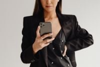 Kaboompics - Close-Up of a Woman Holding a Smartphone in a Black Suit