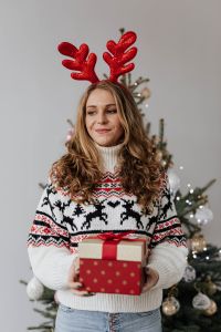 Kaboompics - Woman in Reindeer Antlers Holding a Stack of Christmas Gifts