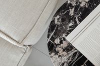 Kaboompics - Round Marble Side Table With Open Book Beside Sofa