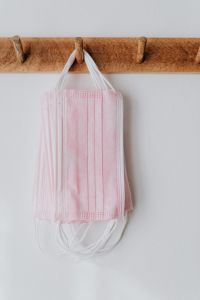 Kaboompics - Pink Disposable Face Masks Hanging from Wooden Rack